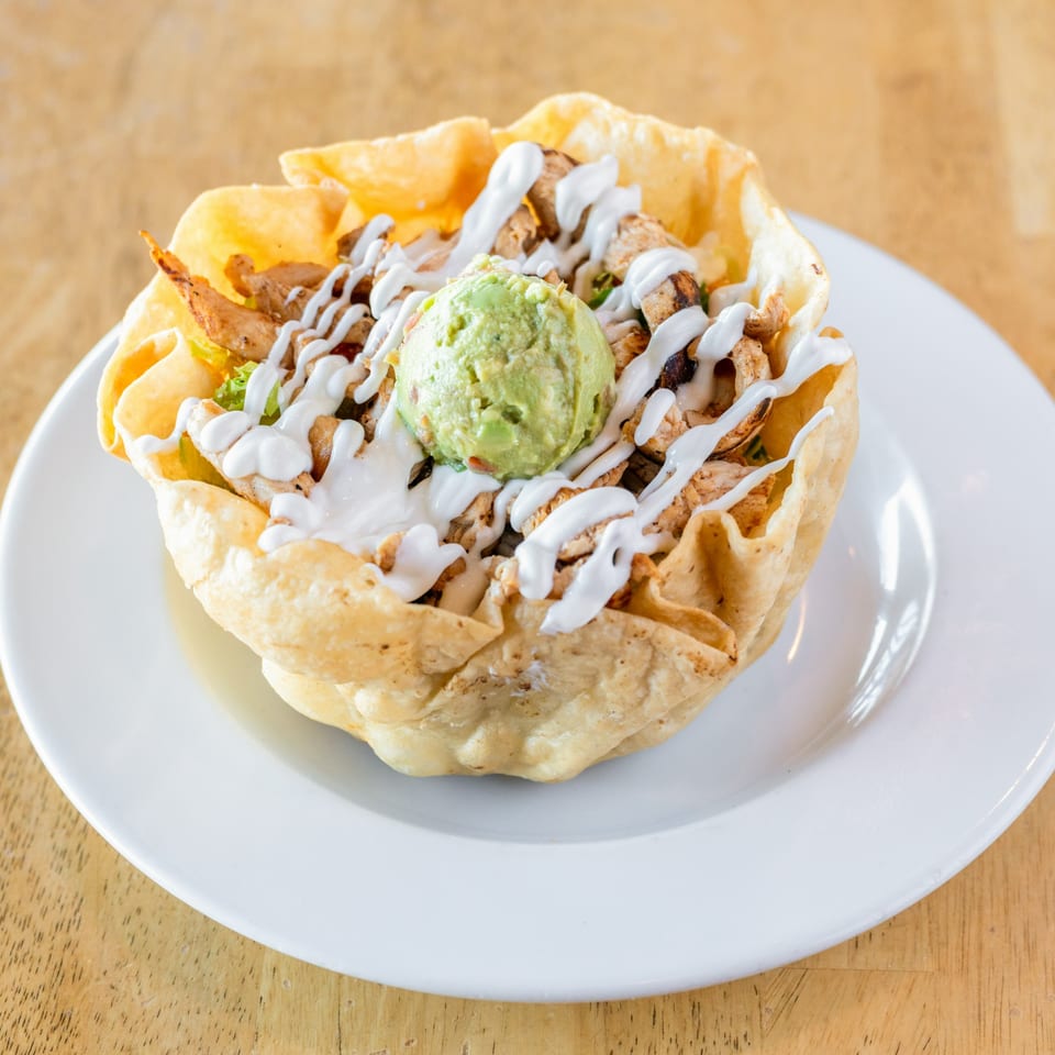 El Chubasco's taco salad with chicken, guacamole, and sour cream in a crispy tortilla bowl.